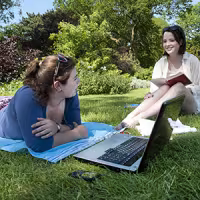 two female students sitting a lawn