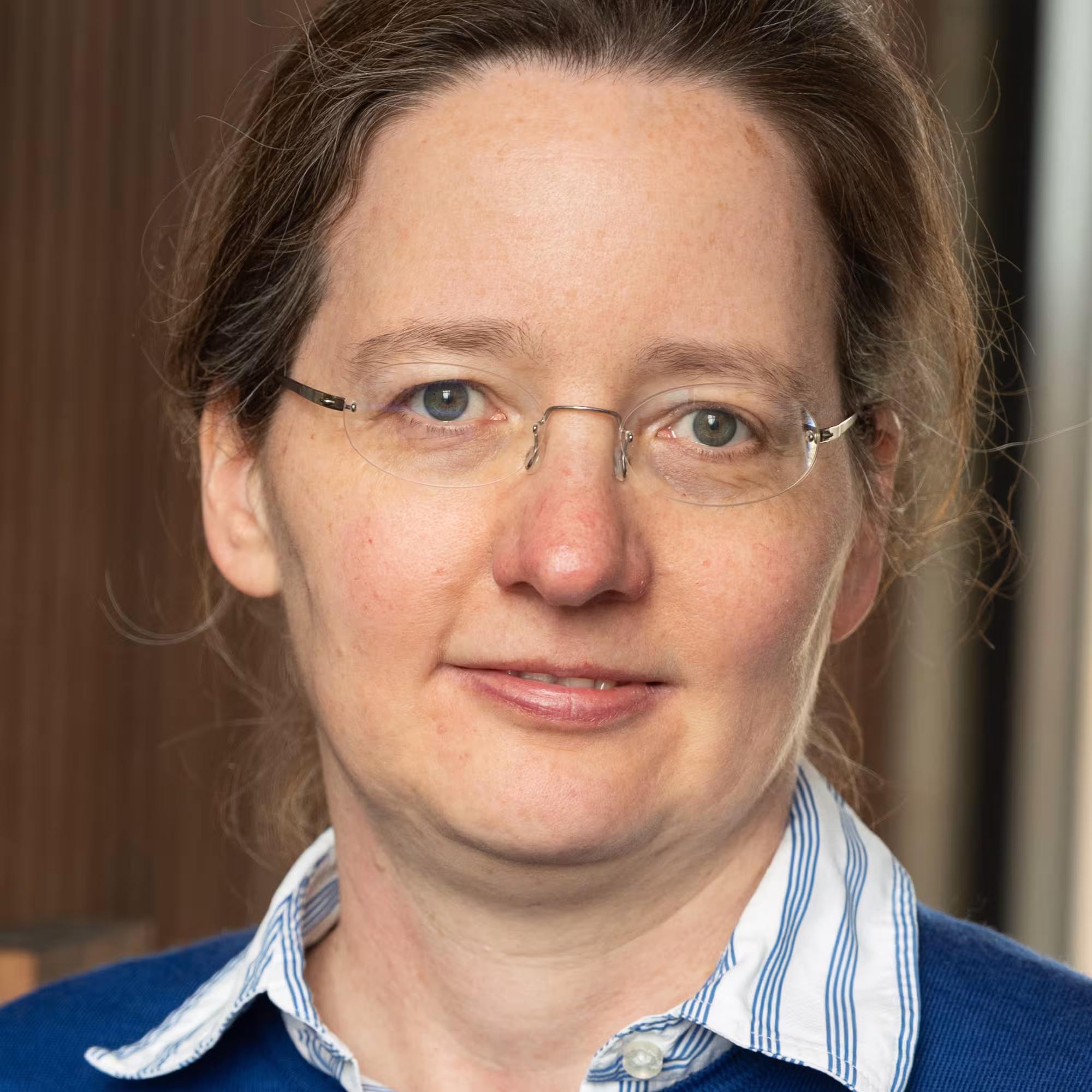 Portrait of Laura Herz, a white woman with long brown hair wearing glasses.
