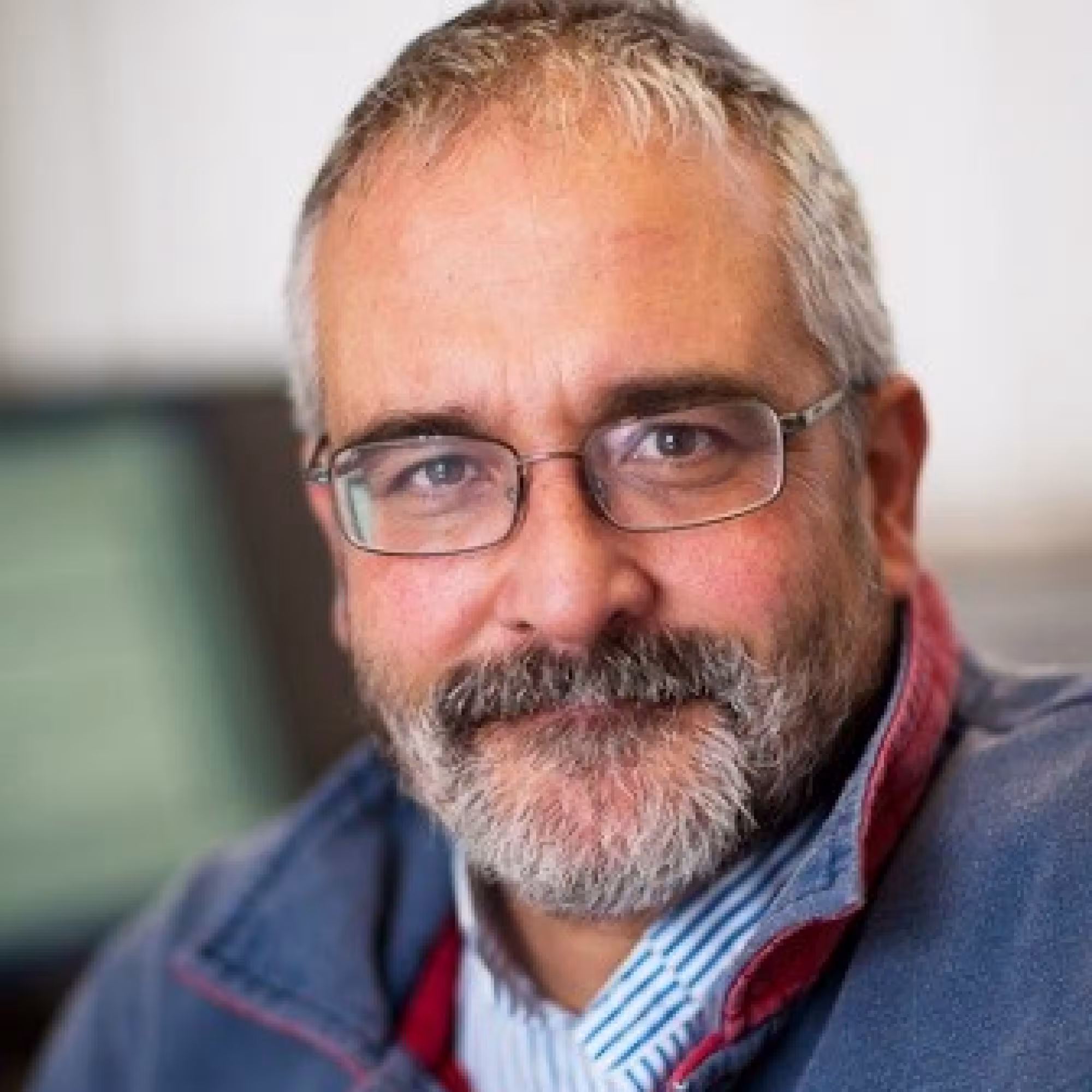 Portrait of Mike Rayner, a white man with short grey hair and a beard, wearing glasses.