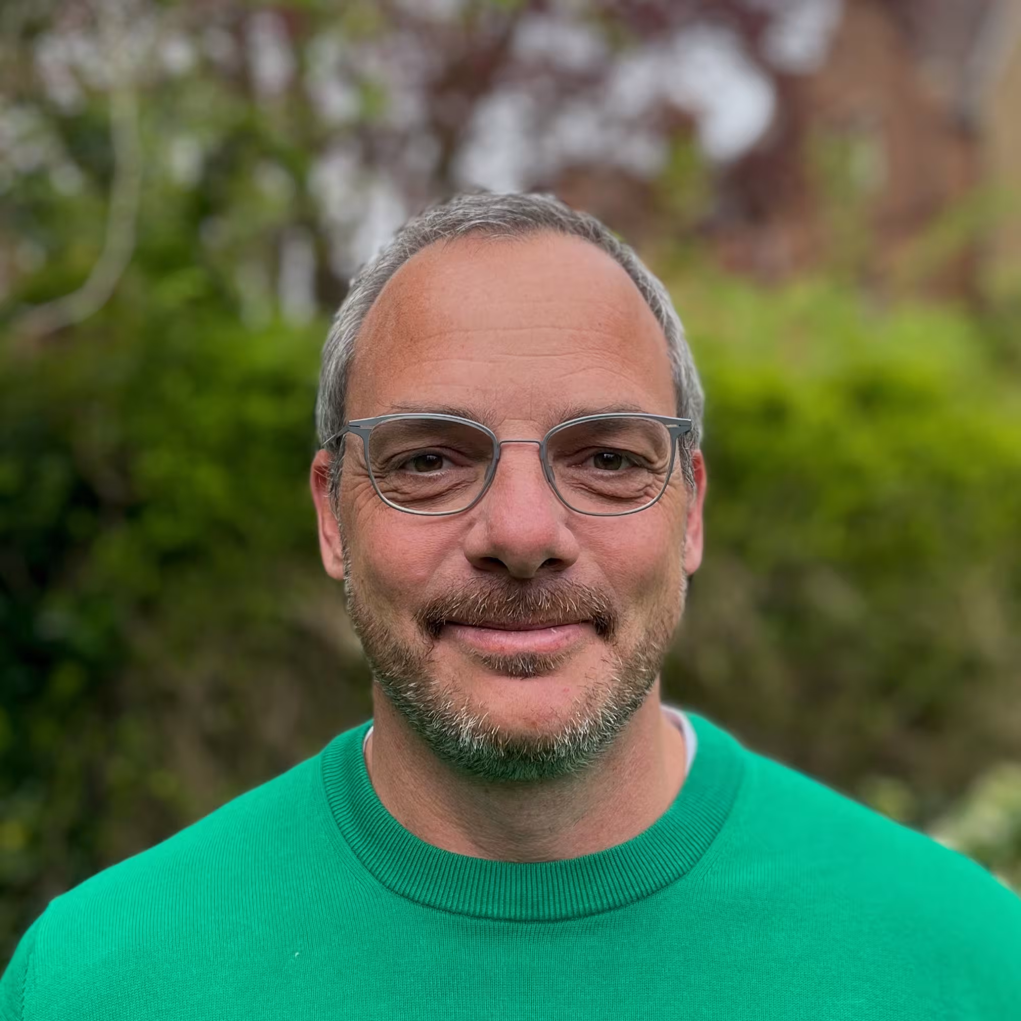 Portrait of Philipp Kukura, a man with short greyish hair and a beard, wearing a green jumper.