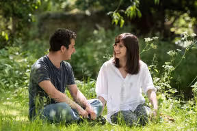 two students sitting in the grass