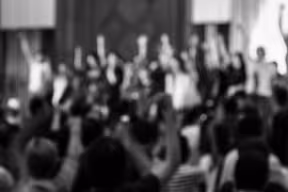 People raising their hands at an event
