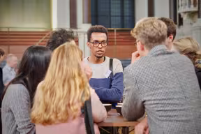 A small group of students stand around a table