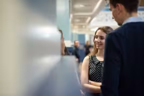 Two students stand and chat 