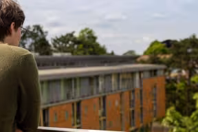 A student looking out from the balcony of the Dickson Poon building