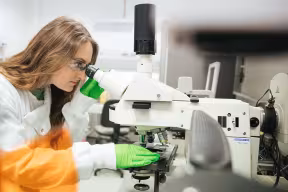 Student looking through a microscope in the laboratory, Medical Sciences Division.