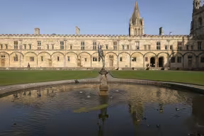 A view across the fish pond in the centre of Tom Quad with a statue of Mercury in the middle