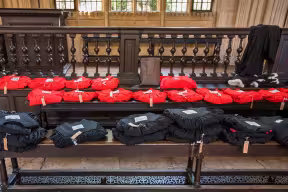 Gowns labelled and waiting for their recipients in the Divinity School.