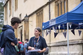 A staff member assisting an open day visitor in oxford