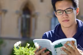 postgrad reading a book outside the Natural History Museum