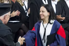 DPhil students shake the Vice-Chancellor's (Professor Andrew Hamilton) hand as they receive their degrees.