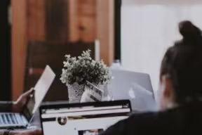 Group of students working around a table on laptops