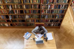 Student reading in the Howard Piper library, St Hugh's College.