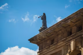 A statue of a Greek muse on top of the Clarendon Building