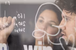 Researchers writing on a glass window
