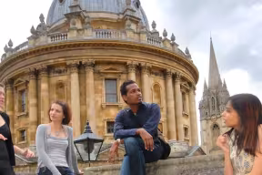 Group of graduate students chatting in Exeter College Fellows' Garden
