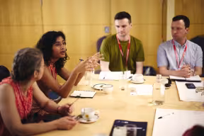 Researchers and policy professionals engaged in a roundtable discussion during a policy workshop