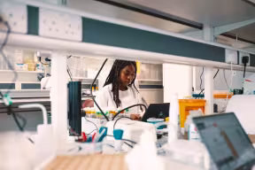 A UNIQplus participant at work in a laboratory.