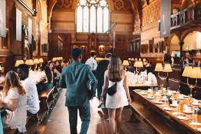 Graduate Access Programme participants attending a social event in a college dining hall.