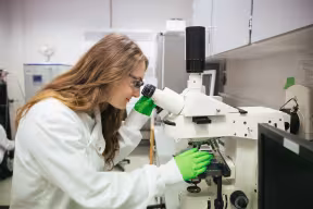 Student looking through a microscope