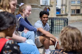 GROUP OF STUDENTS CHATTING ON THE STEPS