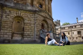 Students talking on the grass outside the Radcliffe Camera
