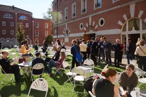 A group of people mingling on a lawn in the sunshine