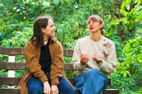 Students sitting on a bench in an Oxford college