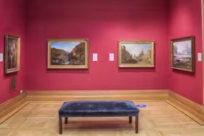 A room with red walls and paintings on the walls
