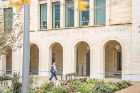 A student walks up to the entrance of a large building 