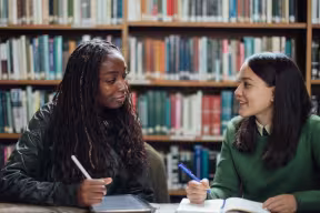 students chatting in a library