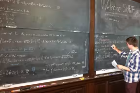 Student writing on a blackboard