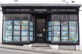 The outside of an estate agent building front windows