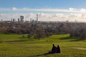 People watching London skyline from a park
