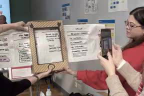 Three women work together on a board during a user experience exercise