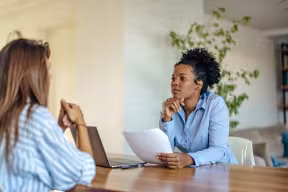 Two people having a conversation across a table.
