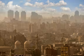 Cairo cityscape with mosques and buildings emerging from polluted air