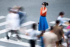 Woman in sunglasses on a busy crosswalk