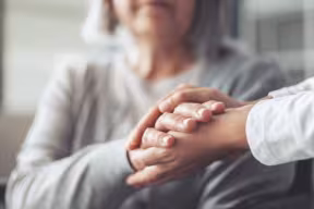 Adult social care. Holding older woman's hands.