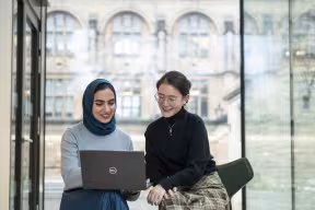 A COUPLE OF STUDENTS LOOKING AT A LAPTOP, RHODES HOUSE