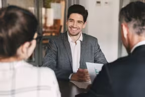 Person smiling confidently in interview in front of a panel
