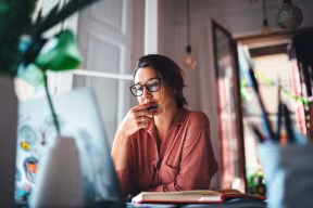 Person thinking in front of laptop