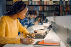 Student working on laptop in library