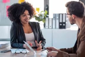 Two professionals discussing a project during a business consultancy meeting.