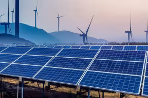 Solar panels in front of wind turbines