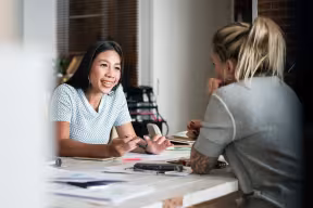 Two people talking and smiling in work meeting