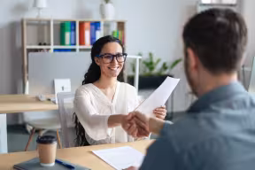 Two people shaking hands in office interview