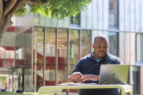 GRADUATE STUDENT STUDYING OUTSIDE OF THE DR LEE SHAU KEE BUILDING,WADHAM COLLEGE