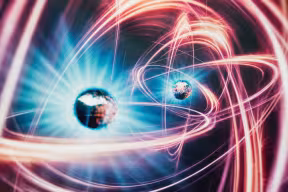 3D rendered image of quantum entanglement. Two suspended particles are connected by spiralling curves of light.