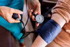 Caregiver measuring patient's blood pressure at home